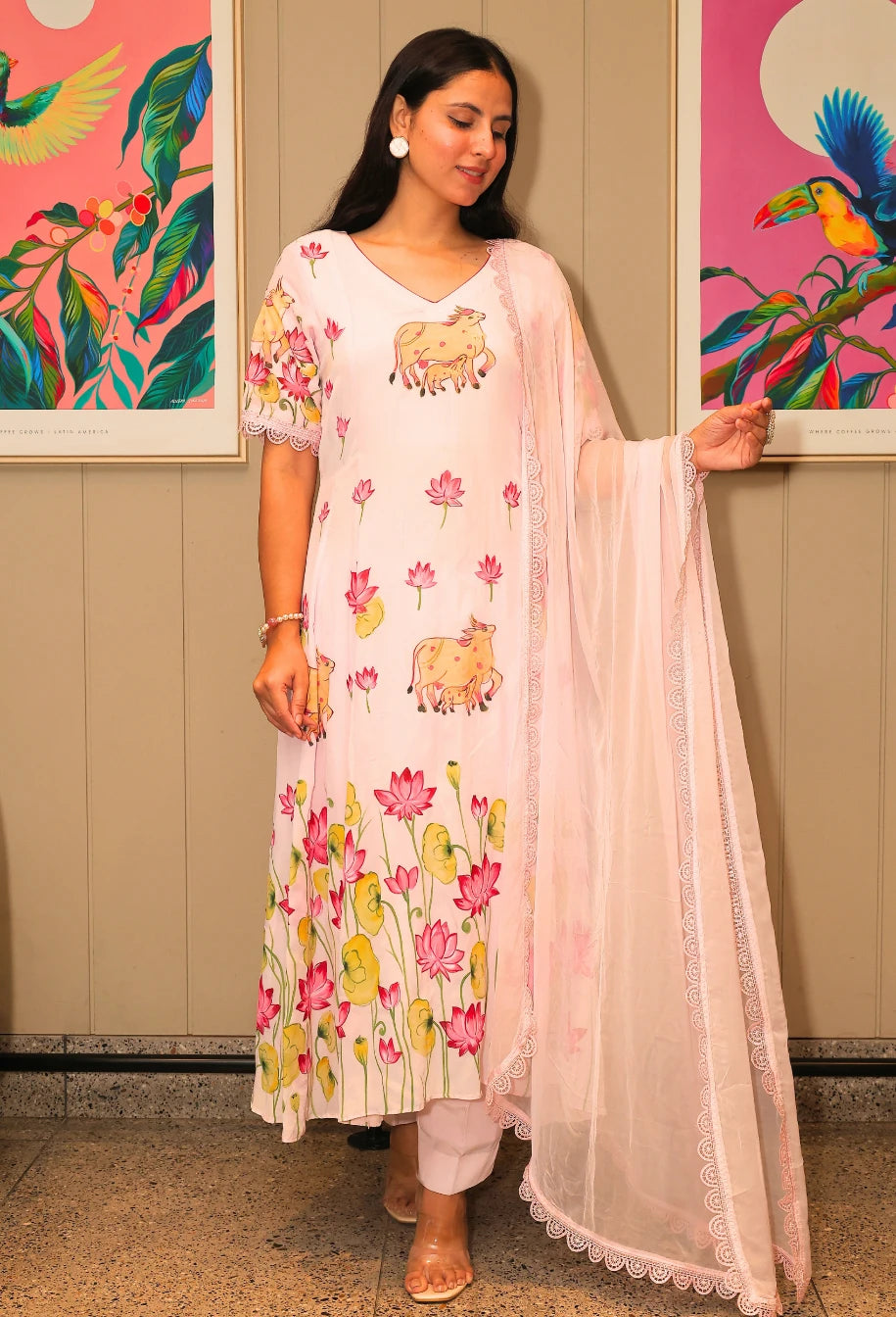 Lotus Reverie from Destiny by Anjali, a stunning designer traditional suit crafted from soft cotton. This baby pink ensemble features beautiful hand-painted lotus flowers that add a touch of elegance and charm. Fully lined and designed for all-weather comfort, this piece is a trending choice for occasion wear. Whether attending a festive celebration or a casual gathering, this suit is perfect for all occasions, seamlessly blending traditional artistry with modern style.