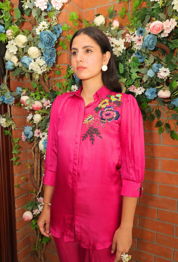 the Empress Embellish from Destiny by Anjali, a striking designer coord set in hot pink. Crafted from luxurious bombarg satin fabric, this outfit features exquisite hand-embroidered floral beaded designs on the shoulders, adding a regal touch. Fully lined for comfort, this set is ideal for all-weather wear. Perfect for both casual and formal events, this trending piece of western wear combines elegance and style, making it perfect for all occasions and a must-have in your wardrobe.