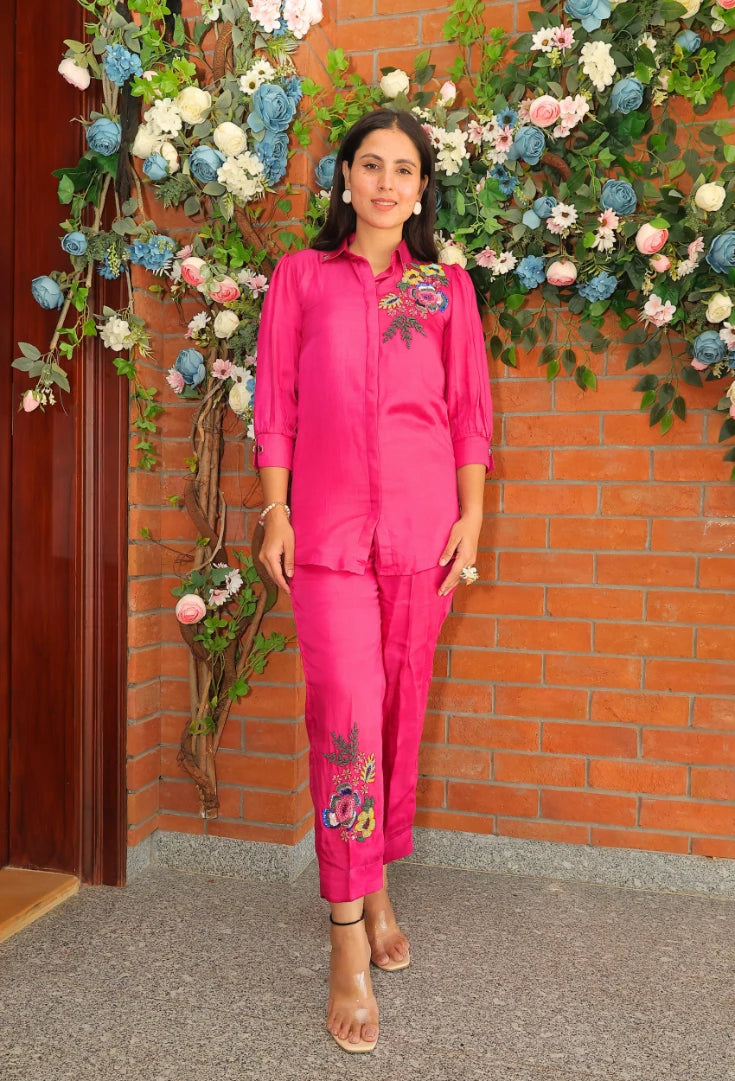 the Empress Embellish from Destiny by Anjali, a striking designer coord set in hot pink. Crafted from luxurious bombarg satin fabric, this outfit features exquisite hand-embroidered floral beaded designs on the shoulders, adding a regal touch. Fully lined for comfort, this set is ideal for all-weather wear. Perfect for both casual and formal events, this trending piece of western wear combines elegance and style, making it perfect for all occasions and a must-have in your wardrobe.