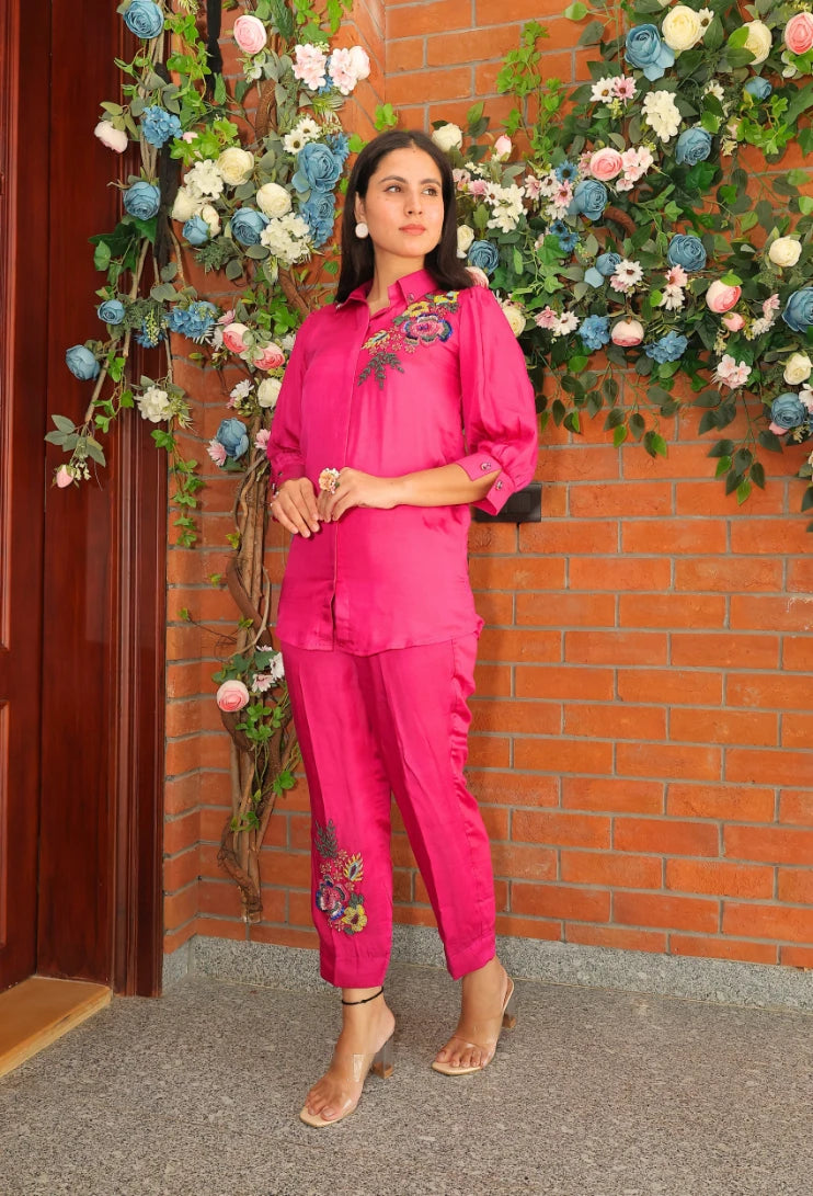 the Empress Embellish from Destiny by Anjali, a striking designer coord set in hot pink. Crafted from luxurious bombarg satin fabric, this outfit features exquisite hand-embroidered floral beaded designs on the shoulders, adding a regal touch. Fully lined for comfort, this set is ideal for all-weather wear. Perfect for both casual and formal events, this trending piece of western wear combines elegance and style, making it perfect for all occasions and a must-have in your wardrobe.