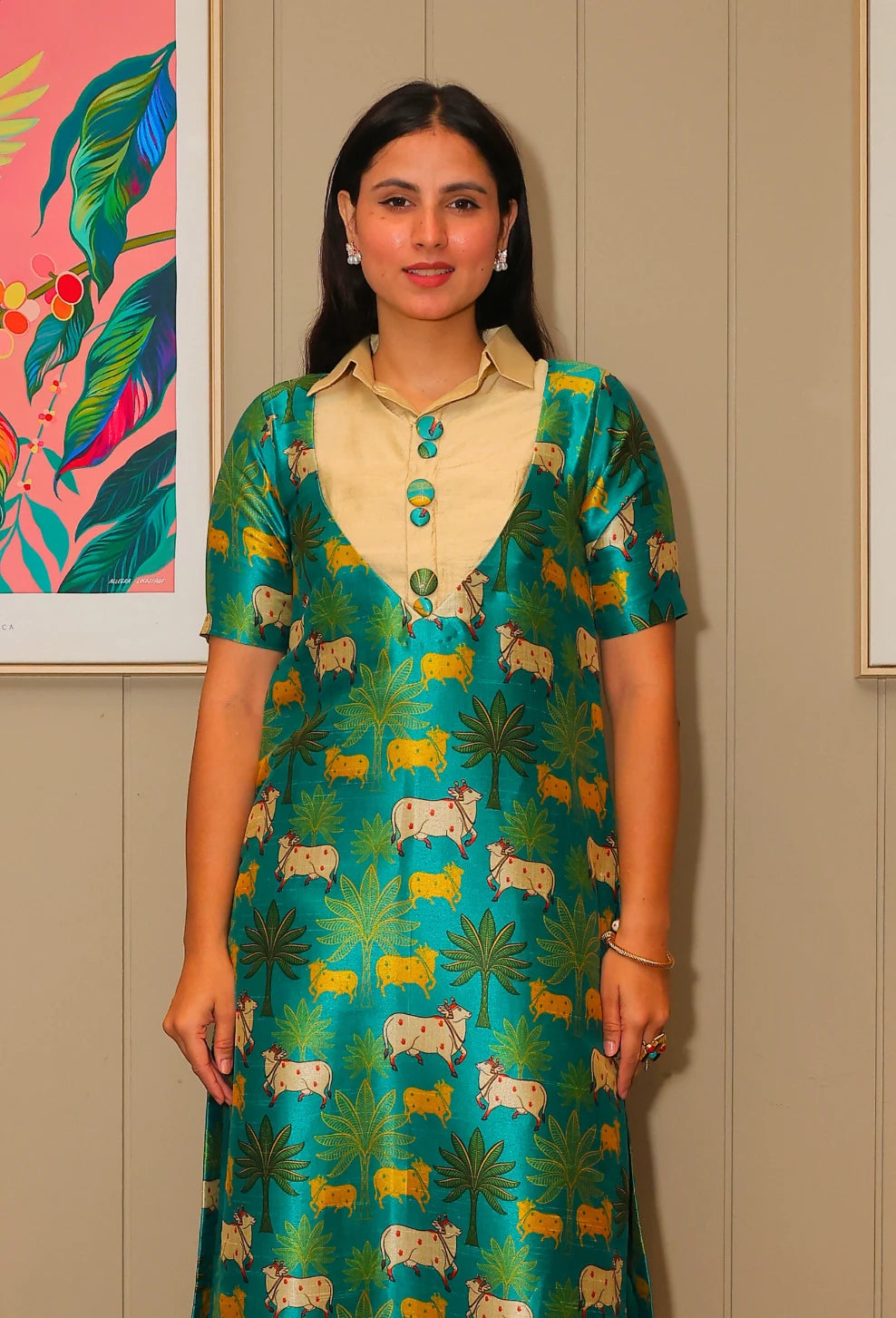 the Kriti Kavya tunic kurti set from Destiny by Anjali. This designer tunic set, crafted from lustrous mango silk fabric in a vibrant green shade, features delicate prints of cows, trees, and bushes inspired by the Madhuvan theme. The shining silk fabric makes it a trending choice for every season, offering comfort and style for all-weather wear. Ideal for festive events or casual outings, this occasion wear kurti set is perfect for all occasions, combining traditional charm with modern flair. Elevate your 