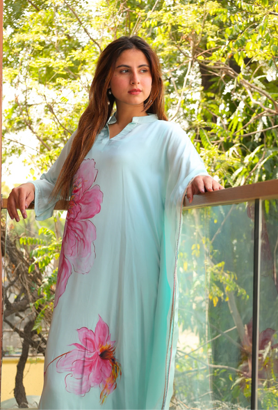 Indulge in the beauty of Pink Blossom, a hand-painted floral kaftan by designer brand, Destiny by Anjal. Made with luxurious modal satin, its cool sea green color evokes a sense of summer breeze. This trendy and new arrival piece will elevate your summer wardrobe. the kaftan comes with an comfortable inner to compensate the see through modal satin fabric.