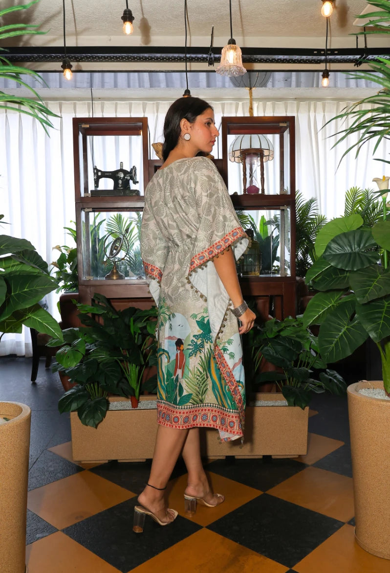 the Oasis Opulence Kaftan from Destiny by Anjali. This designer kaftan in beige and green features a stunning digital print inspired by tribal and beach women. Made from breathable cotton linen fabric, it’s perfect for all-weather wear, keeping you stylish and comfortable. Whether you're lounging at the beach or attending an occasion, this trending Western wear piece is ideal for any event. The kaftan's relaxed fit and intricate print make it a versatile choice for every occasion, blending luxury with comfo